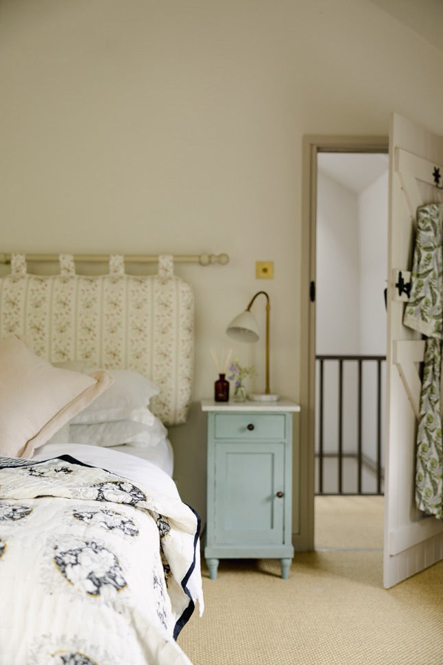 a bedroom with a camellia block printed quilt
