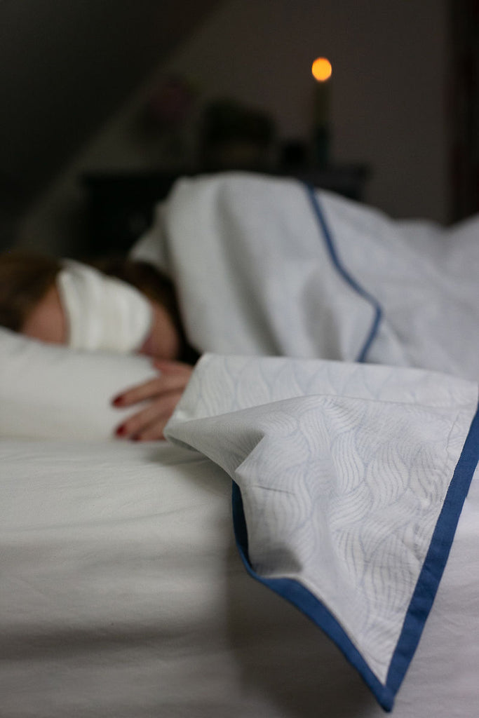 woman sleeping under a dohar blanket 