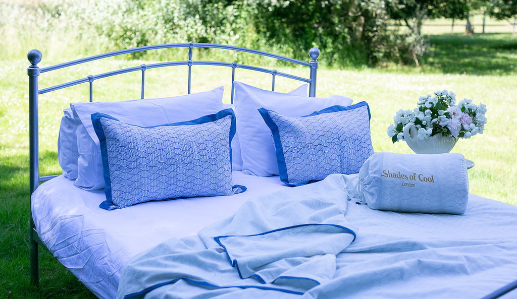 A bed in the garden made up with a Sleep Dohar and quilted pillows