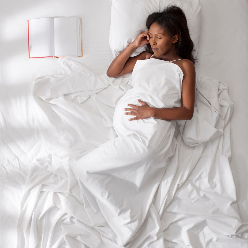 Pregnant Lady asleep on a bed 