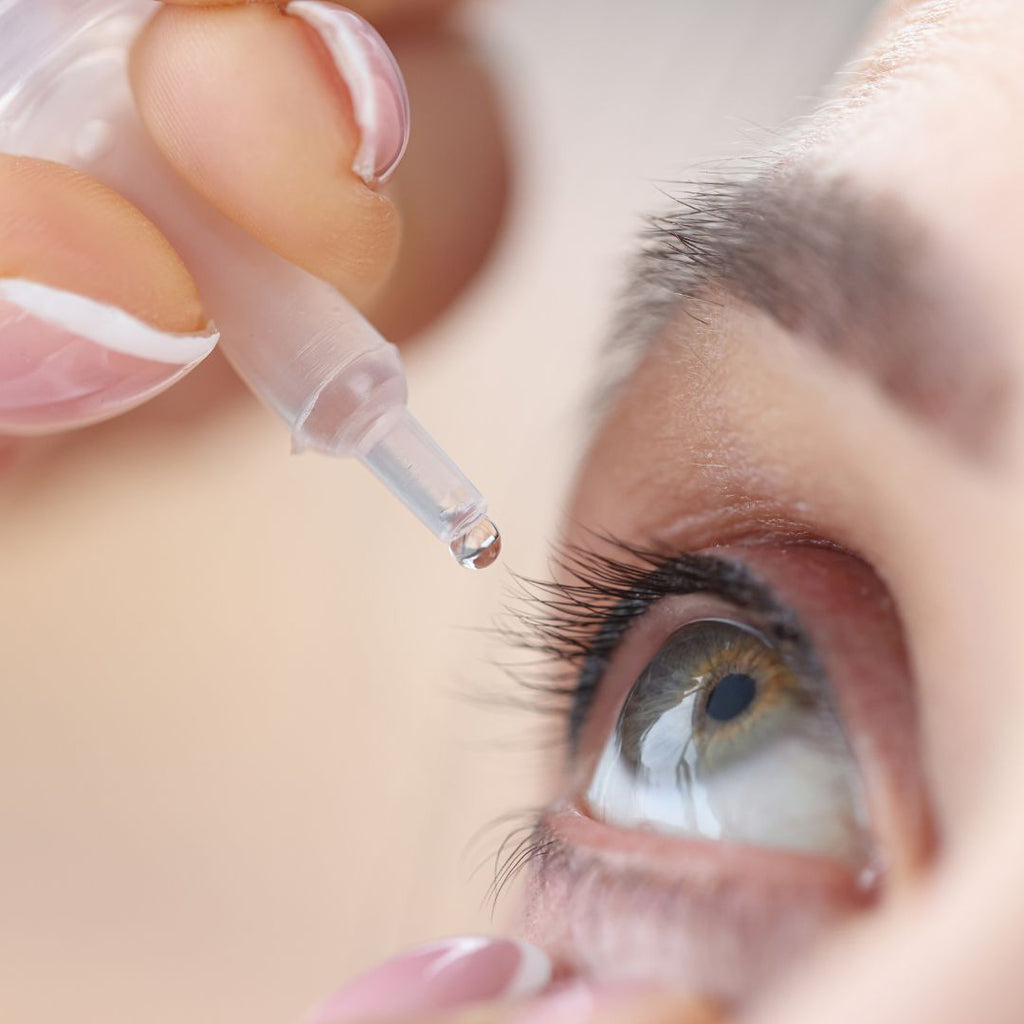 a lady putting drops in eye