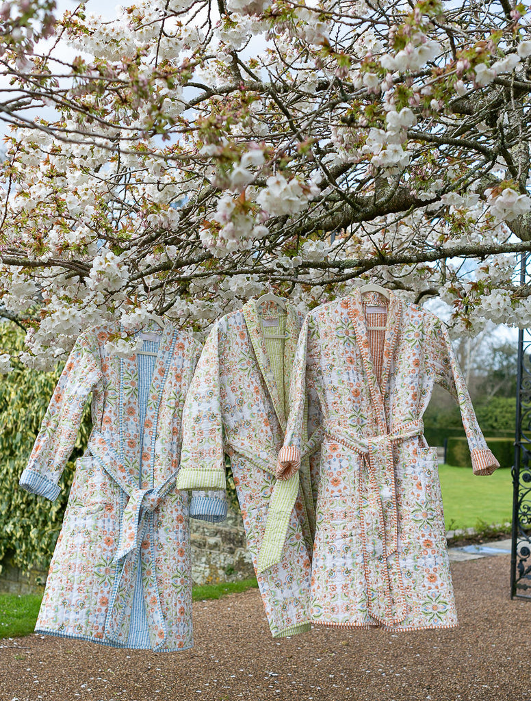 quilted robes hanging from a cherry blossom tree at Cowdray House 