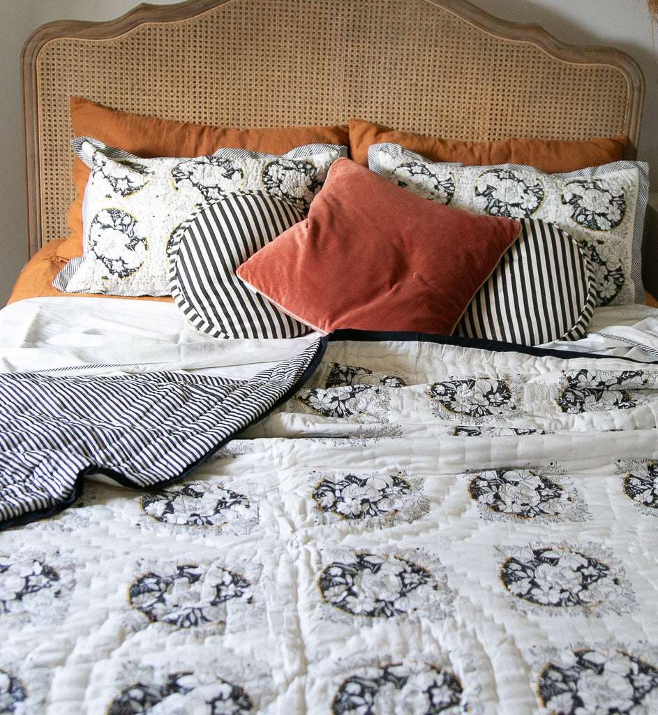 black and white block printed bedding on a bedd, in a camellia design 