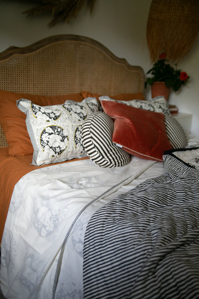 Bed made up with black and white block printed bedding  