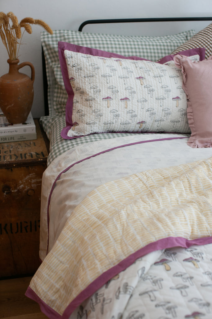 detail of an opne bed with mushroom printed bedding 