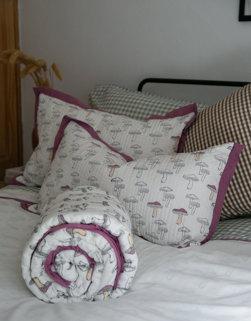 bedset of block printed bedding in a mushroom design displayed on a bed