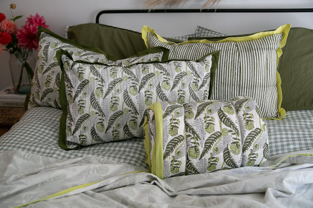 block printed bedding displayed on a bed, green hues, fern design print 