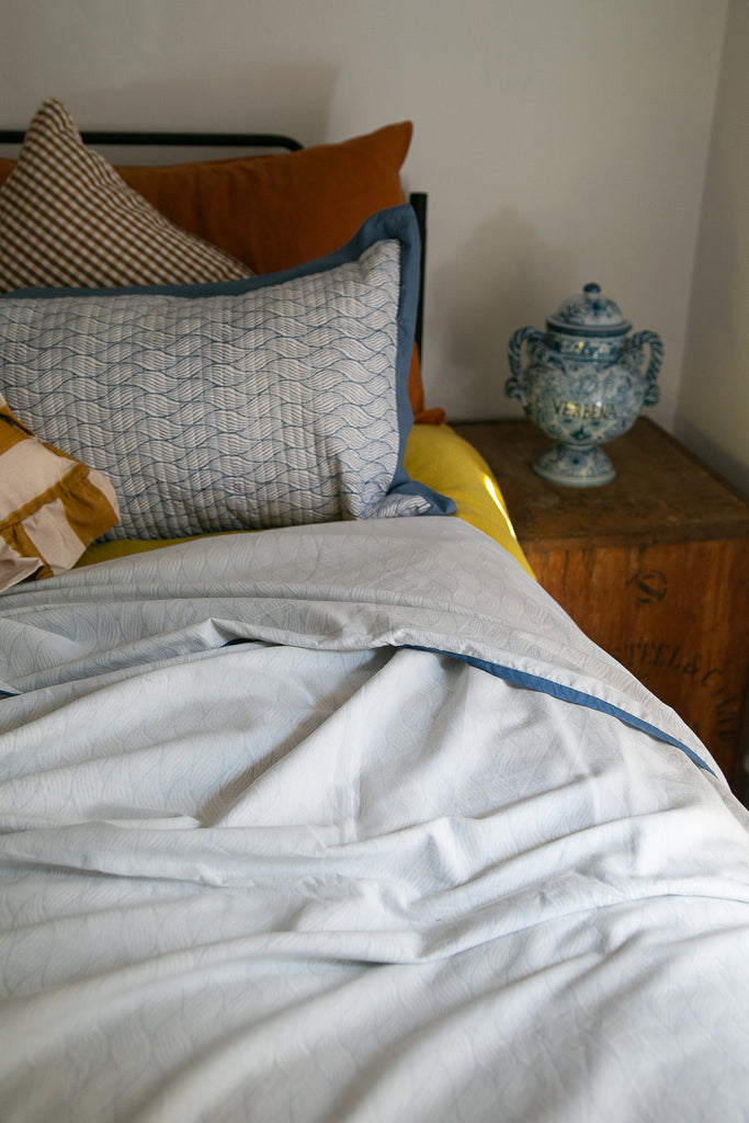 bed detail with an Indian dohar and blue matching pillow