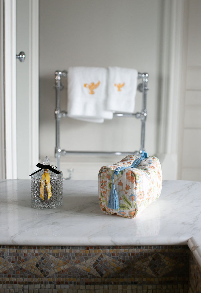 a block printed washabag with sky blue edging on a sink