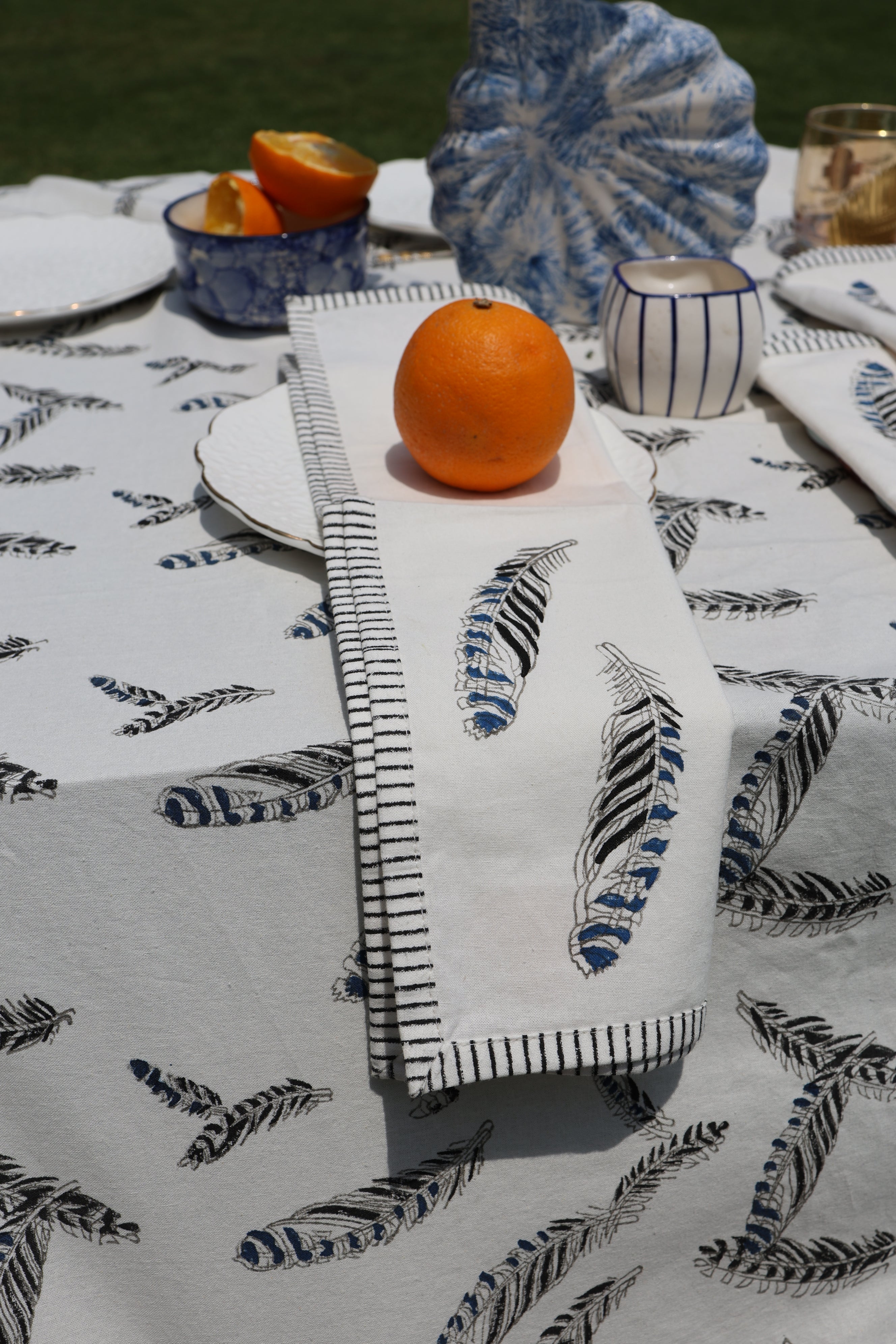 a feather napkin on a tale with an orange 