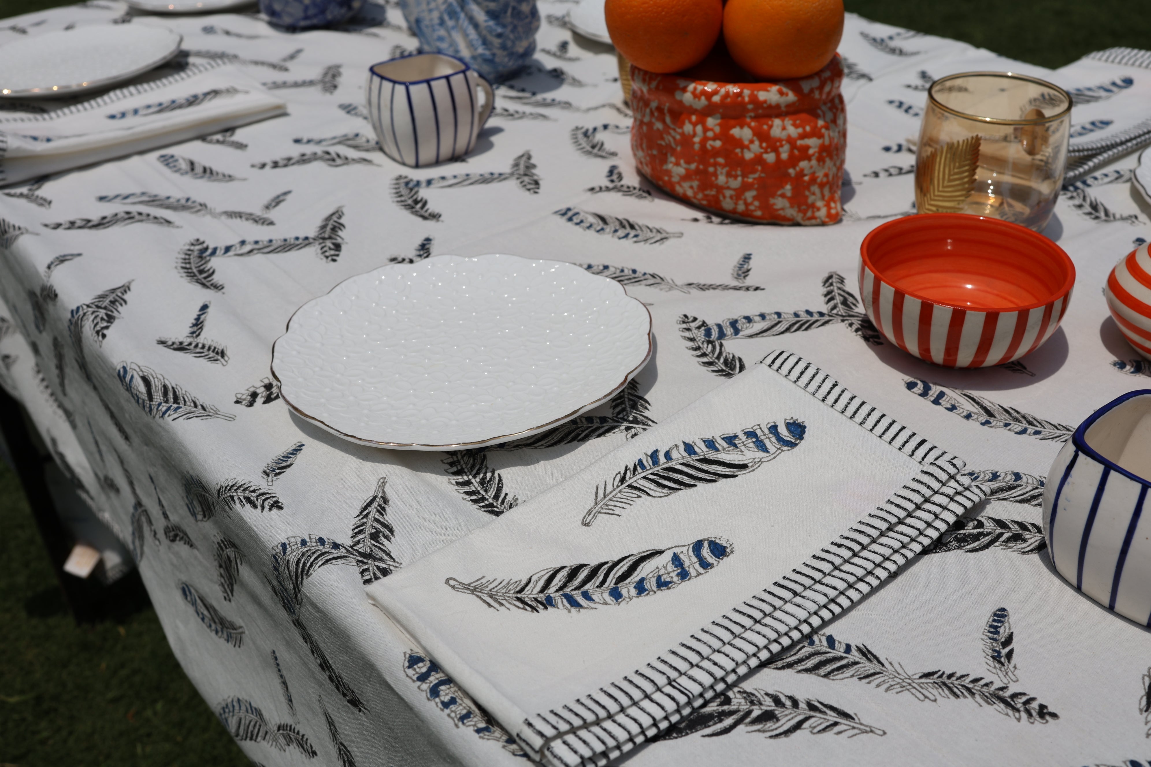 table set for lunch with blue and white feather tablecloth and napkins