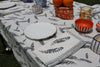 table set for lunch with blue and white feather tablecloth and napkins