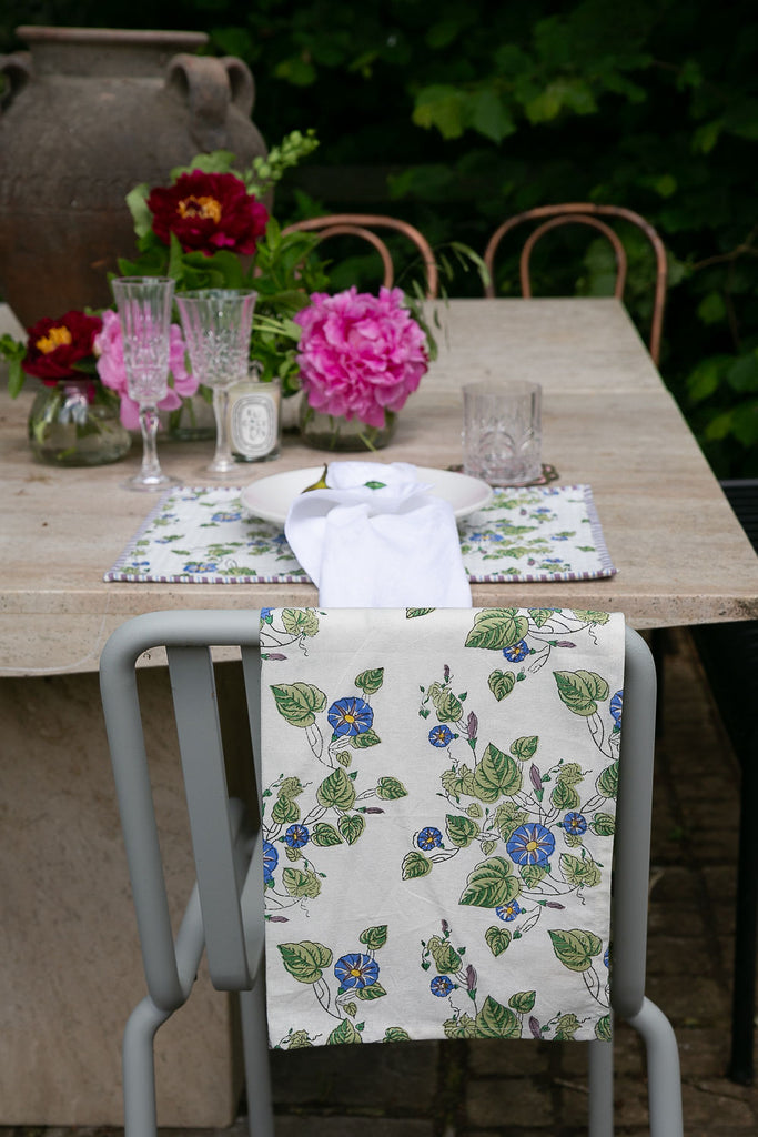 A block printed tea towel hanging on the back of a chair 