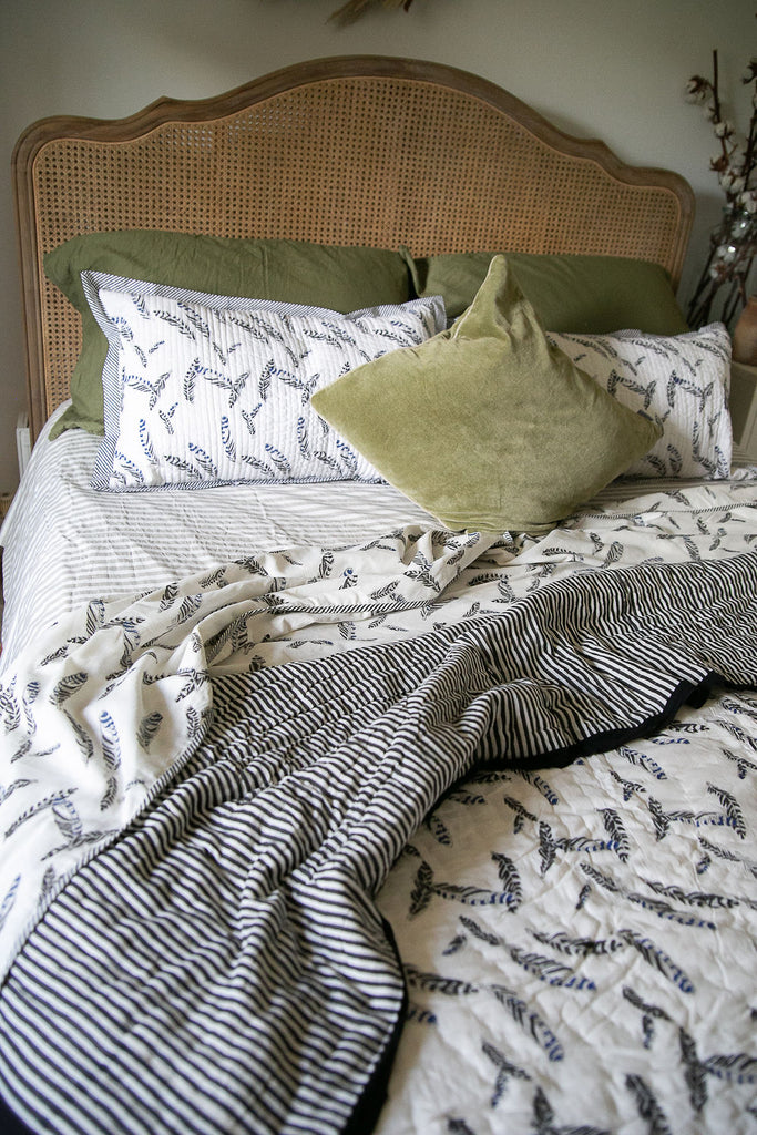 cane bed made up with jay feather block printed bedding 