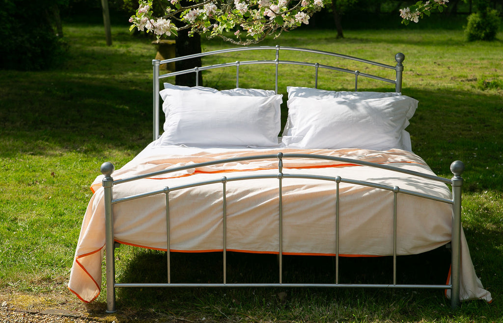 bed in garden with a tangerine sleep dohar 