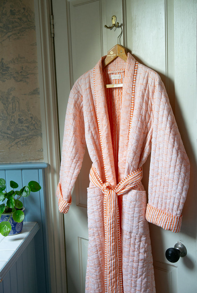 orange printed dressing gown hanging from the back of a door