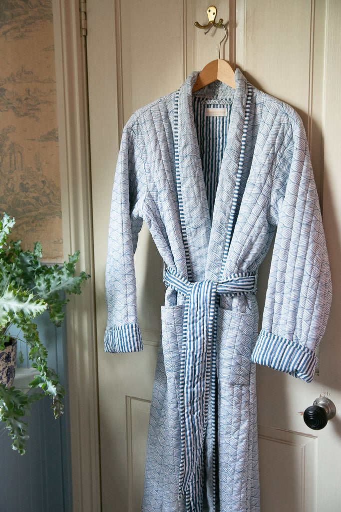 blue block printed robe hanging on a hanger on a bathroom door