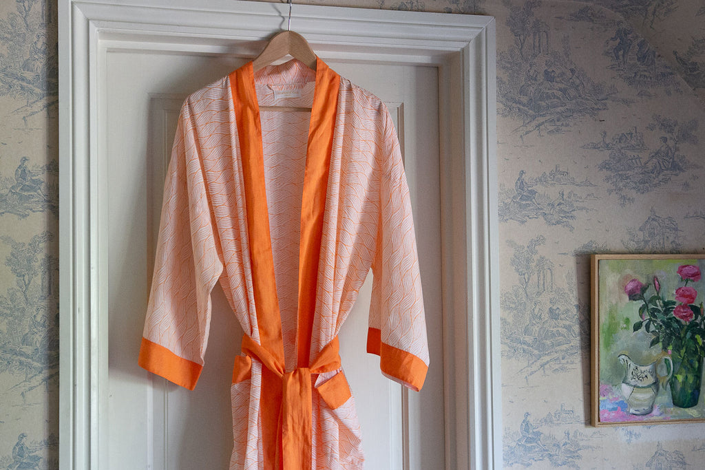 tangerine cotton robe hanging from a door frame 