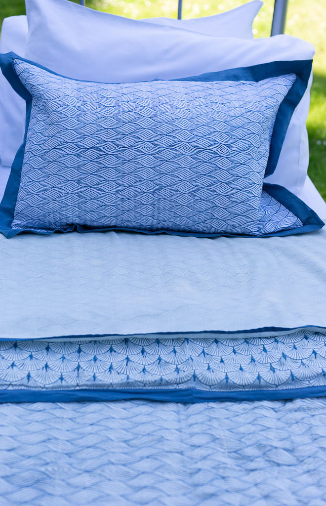 Japanese wave block printed cushion on a bed 