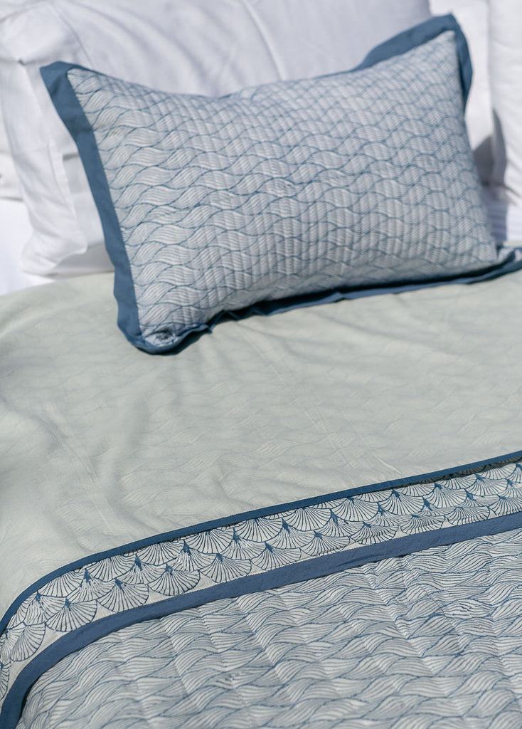 detail of block printed bedding in a blue wave design 