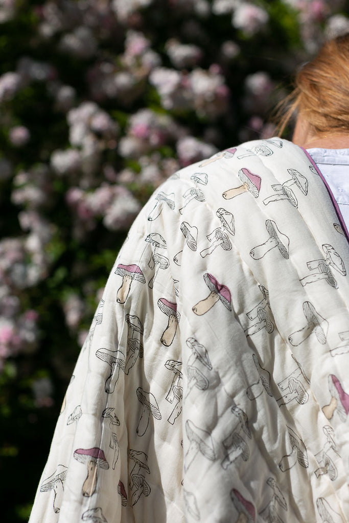 mushroom quilt draped over a ladies shoulder 